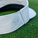Hirondelle brodée sur la visière Commune golf - casquette de golf posée sur un green