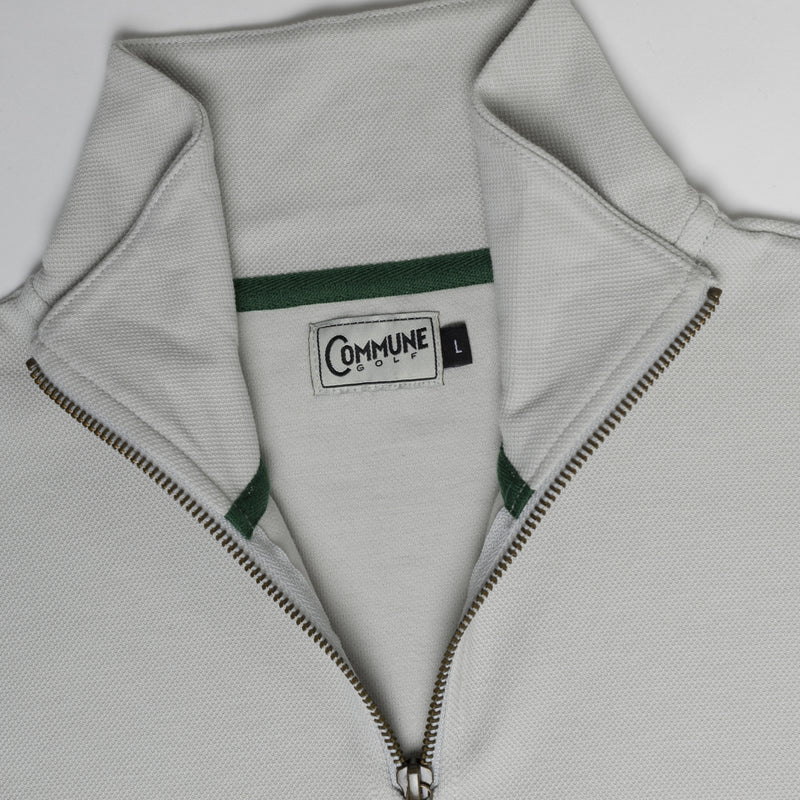 Col du sweatshirt halfzip gris par Commune golf : étiquette tissée commune golf, bande intérieure de col et zip YKK, le tout sur un très beau piqué de coton bio