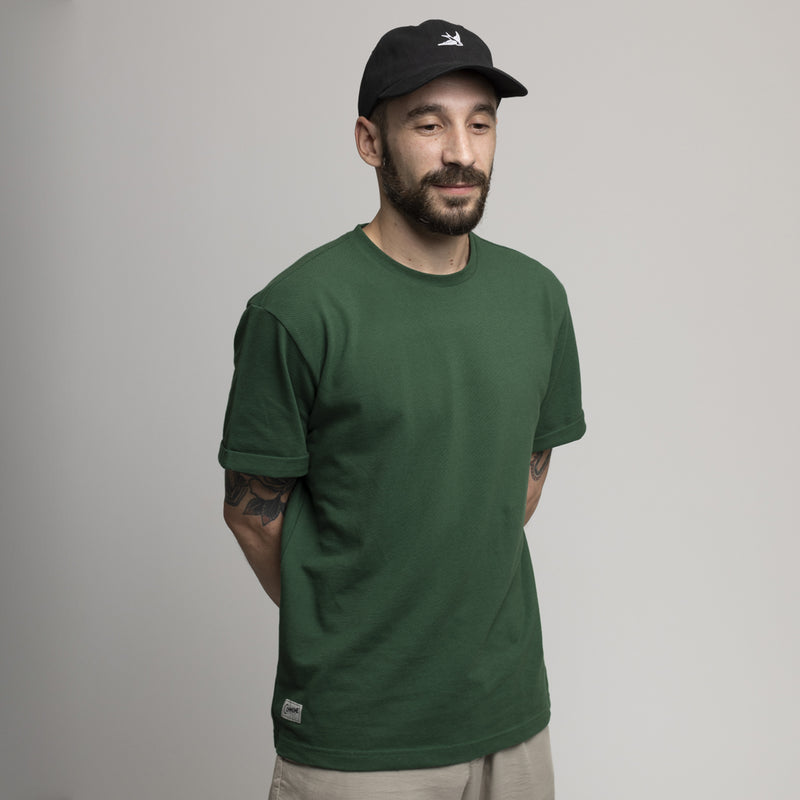 T-shirt vert uni Commune Golf en coton bio porté par un homme
