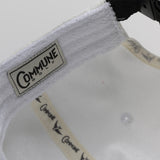 Détails intérieurs de la casquette blanche Commune golf : étiquette et sweatband éponge